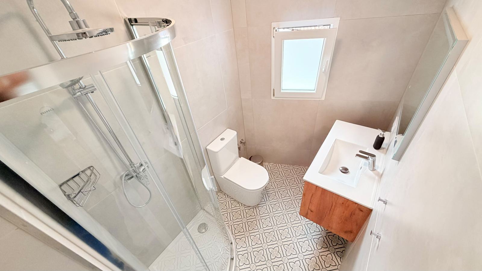 Baño en suite con mampara de ducha y mueble de madera