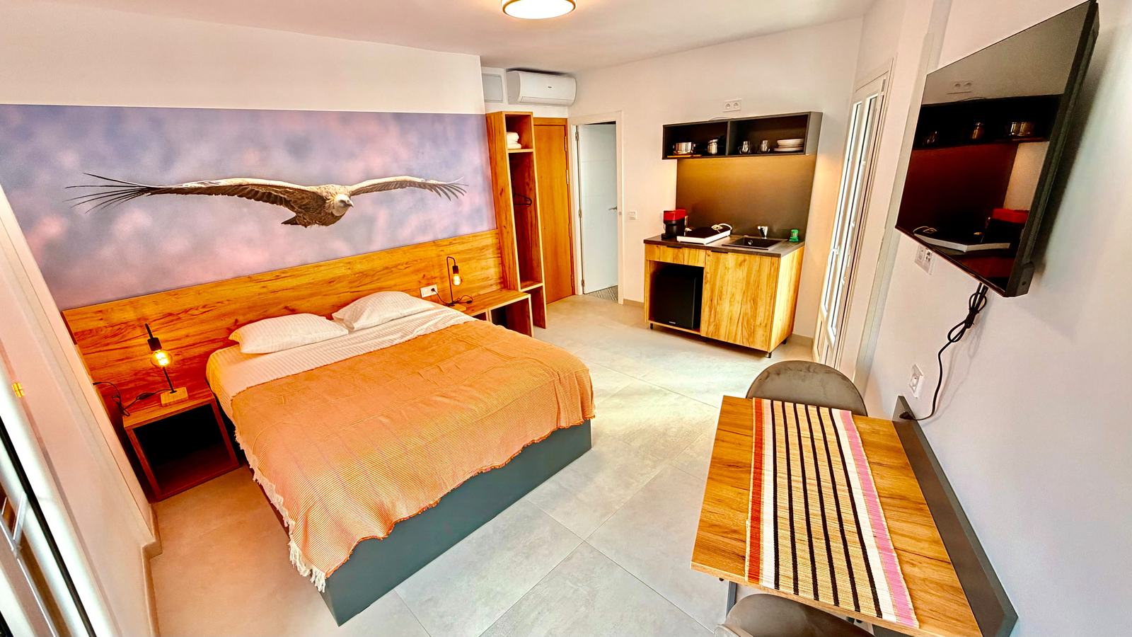 Habitación doble con televisión y mural de buitre